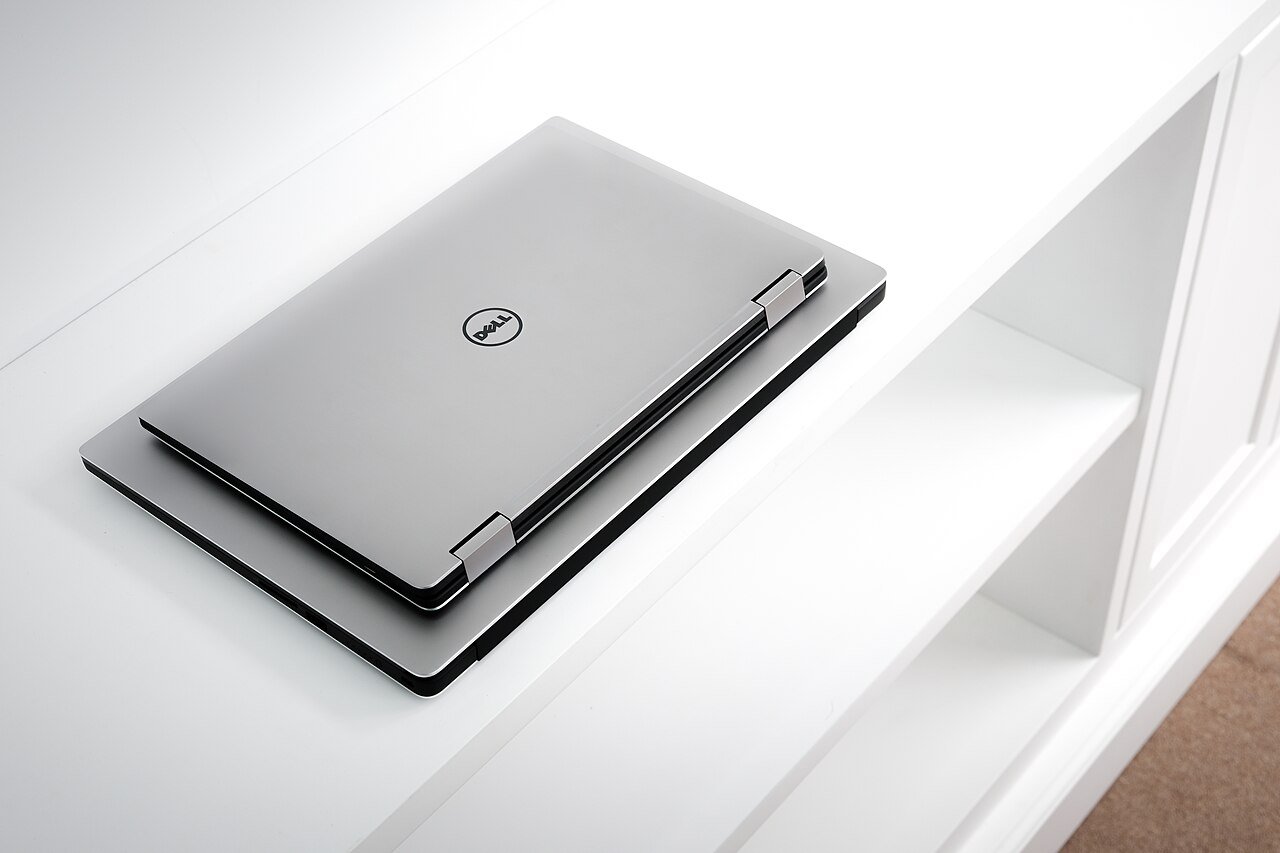 Dell XPS 13 laptop placed on top of a Dell XPS 15 to compare laptop size
