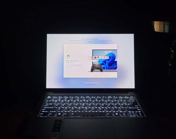 Lenovo IdeaPad Pro 5 laptop running Windows first setup in a dark room with backlit keyboard