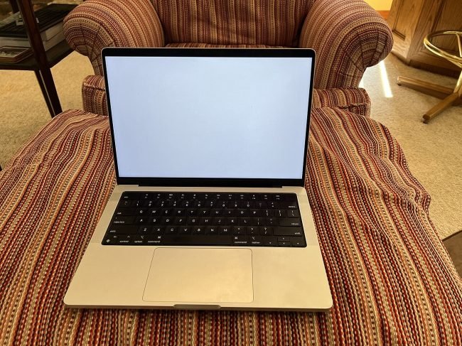 14-inch MacBook Pro open on an armchair