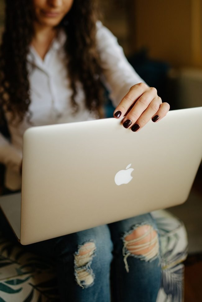Woman holding a thin laptop on her lap